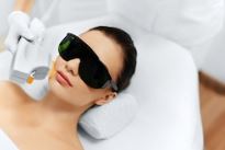 woman lying down with eye protection on while receiving picosecond laser aesthetic treatment